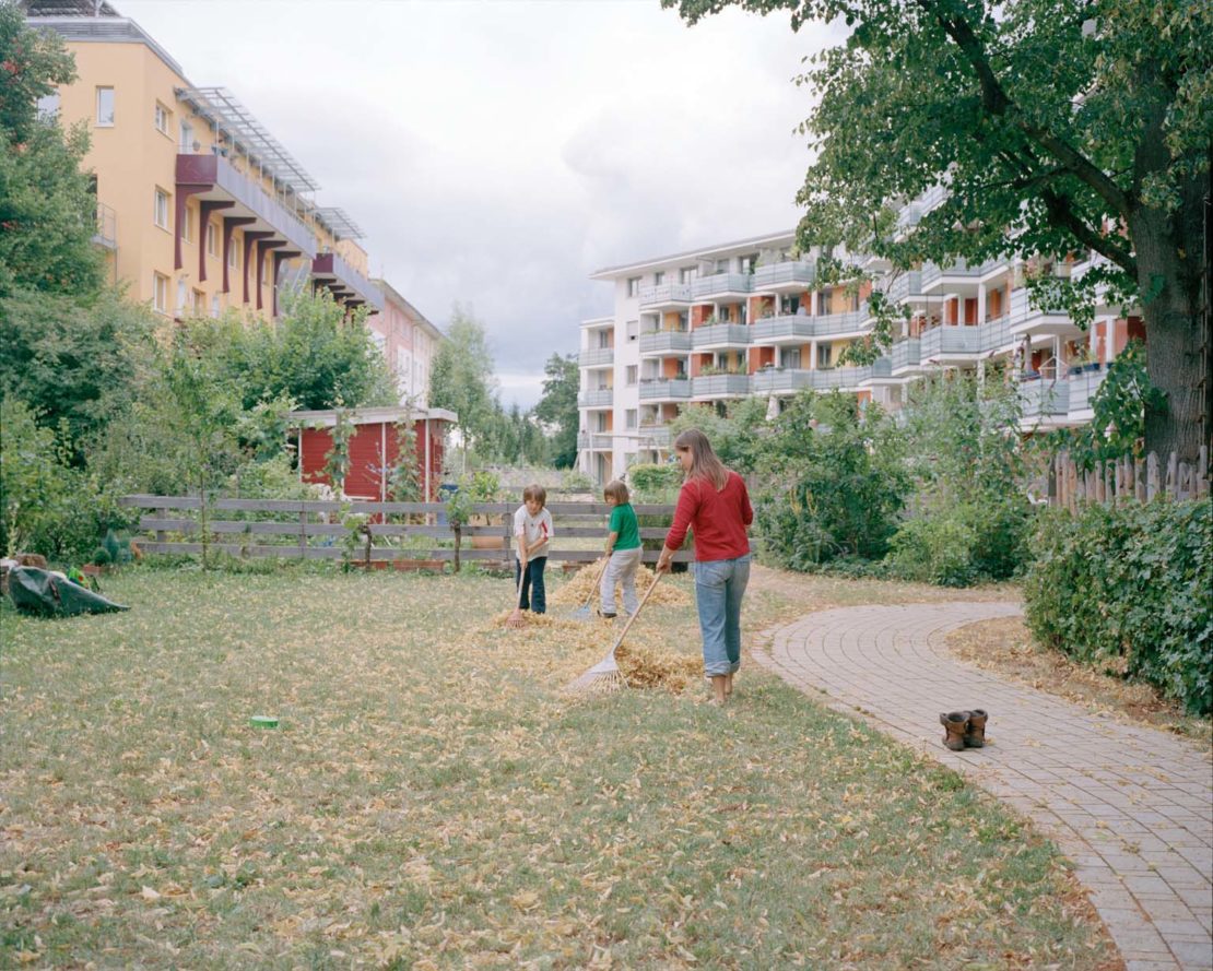 Family sweeping leaves in Vauban